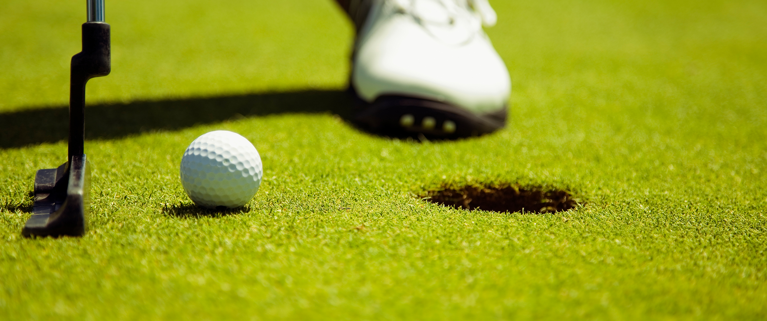 adult male playing golf in country club. The man is preparing to hit the ball