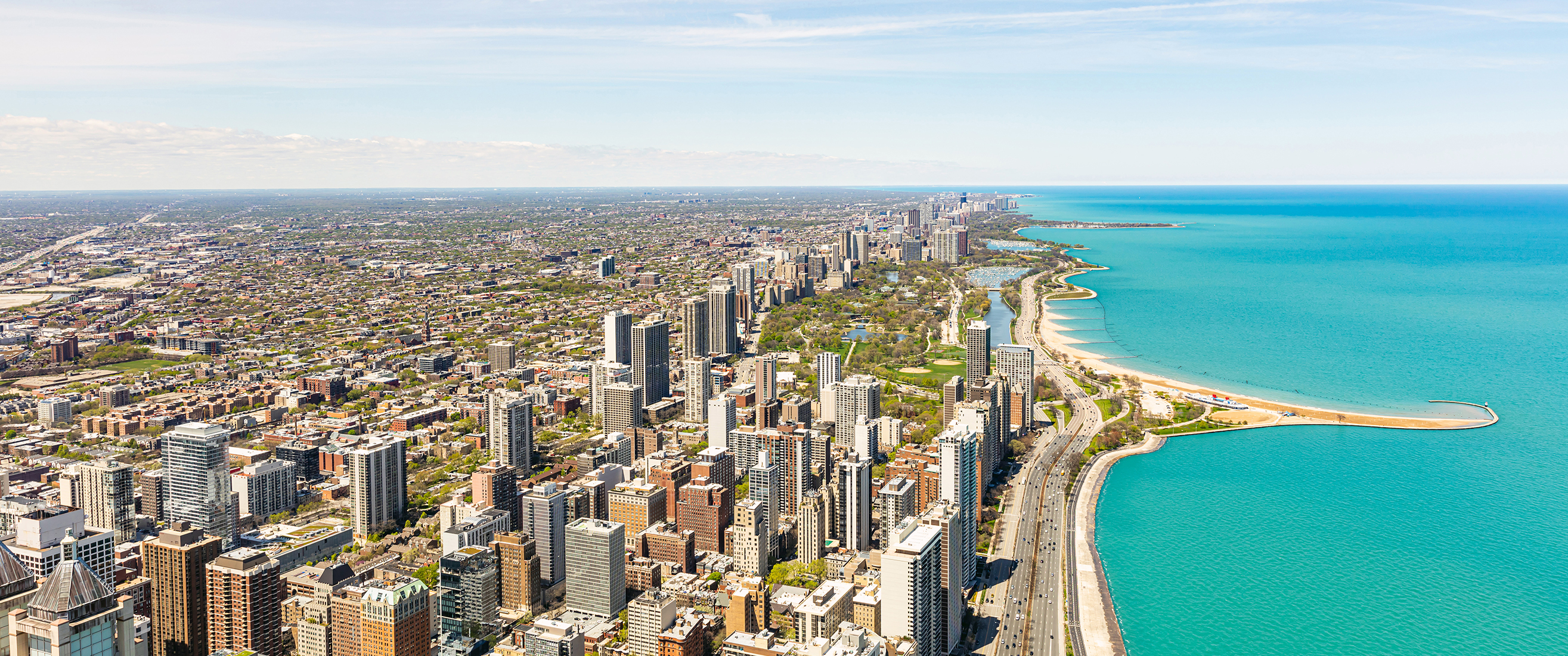 Chicago panorama. Cityscape aerial view, spring day. High rise buildings and lake Michiganl, blue sky background. High angle panoramic view from skydeck